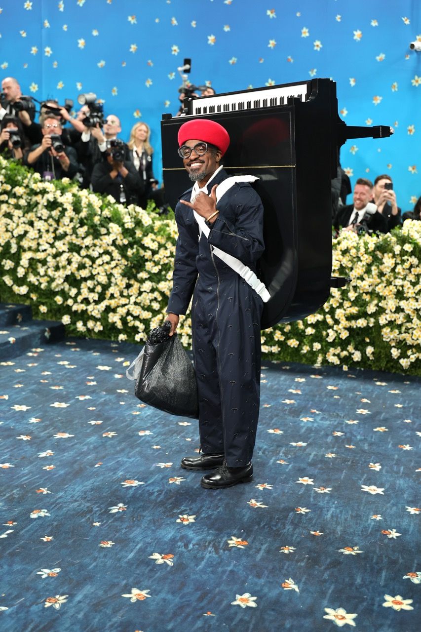 André 3000 arrives at the Met Gala with a piano and trash bag in an outfit by Burberry