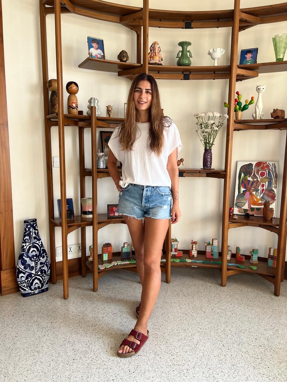 Baker Janki Thackersey in a white T-shirt, denim shorts, and Birkenstocks