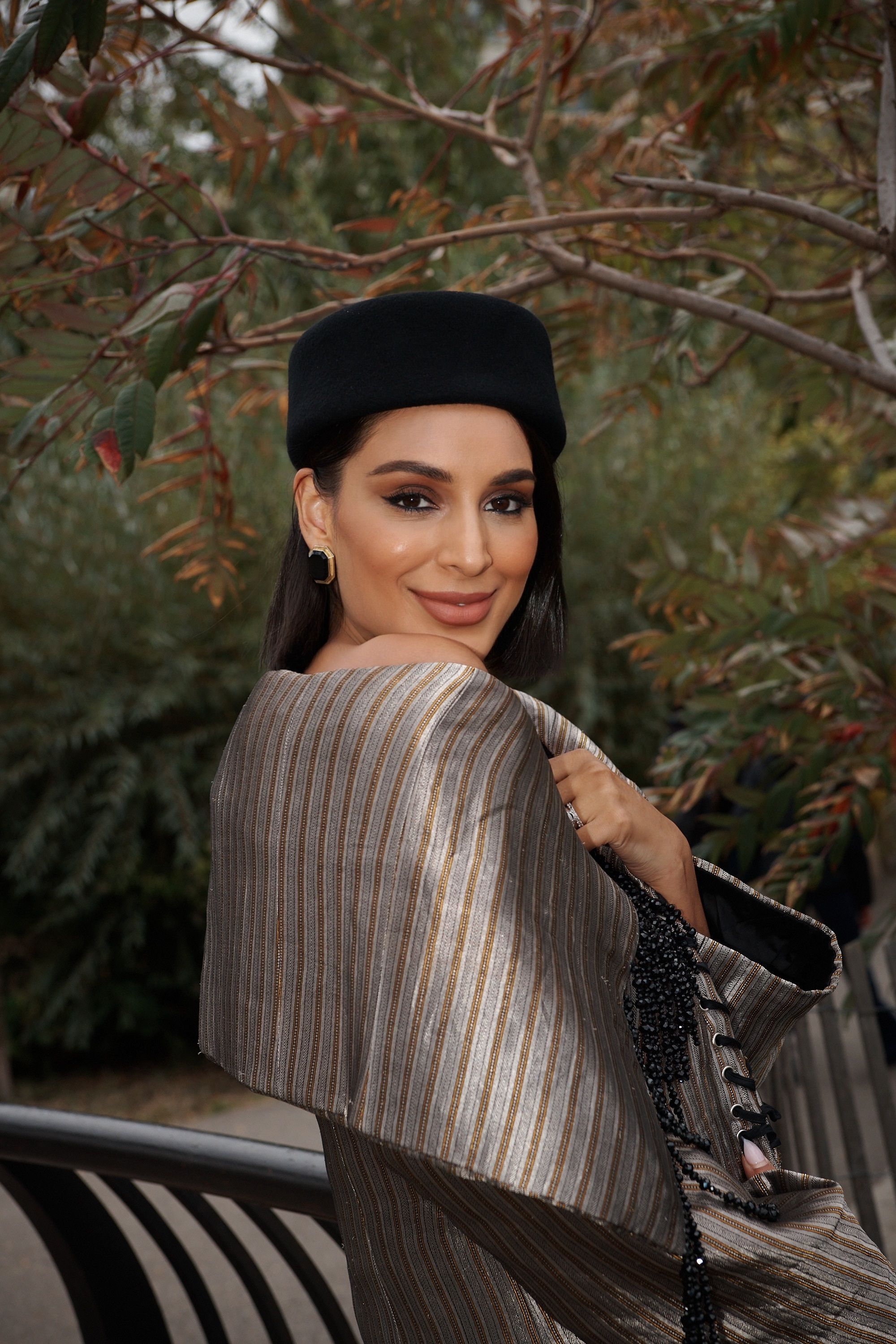 Jessel Taank in a Réik off-shoulder jacket, Demarson earrings, Gigi Burris pillbox hat