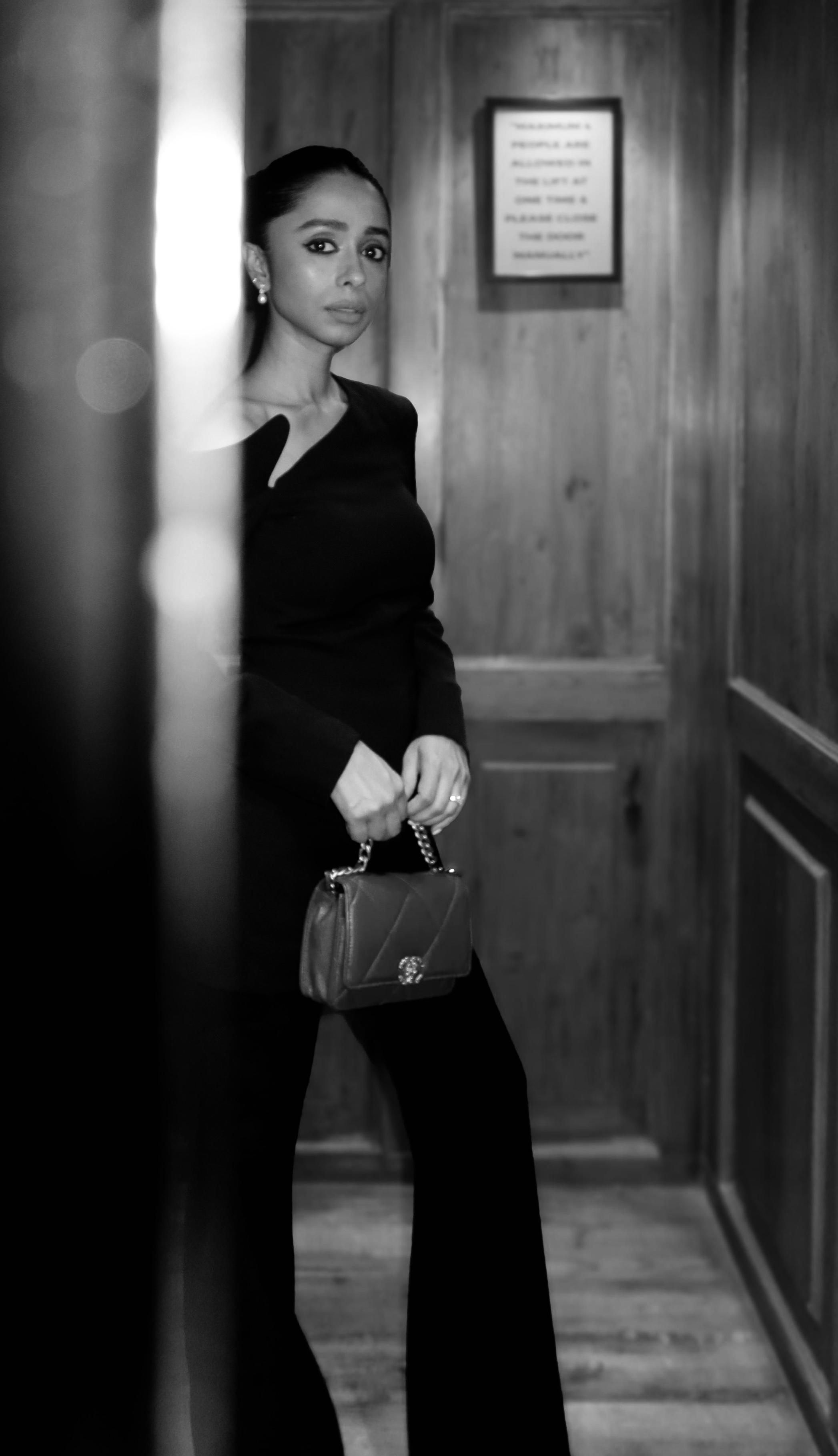 Smridhi Sibal in a black outfit holding a Chanel bag