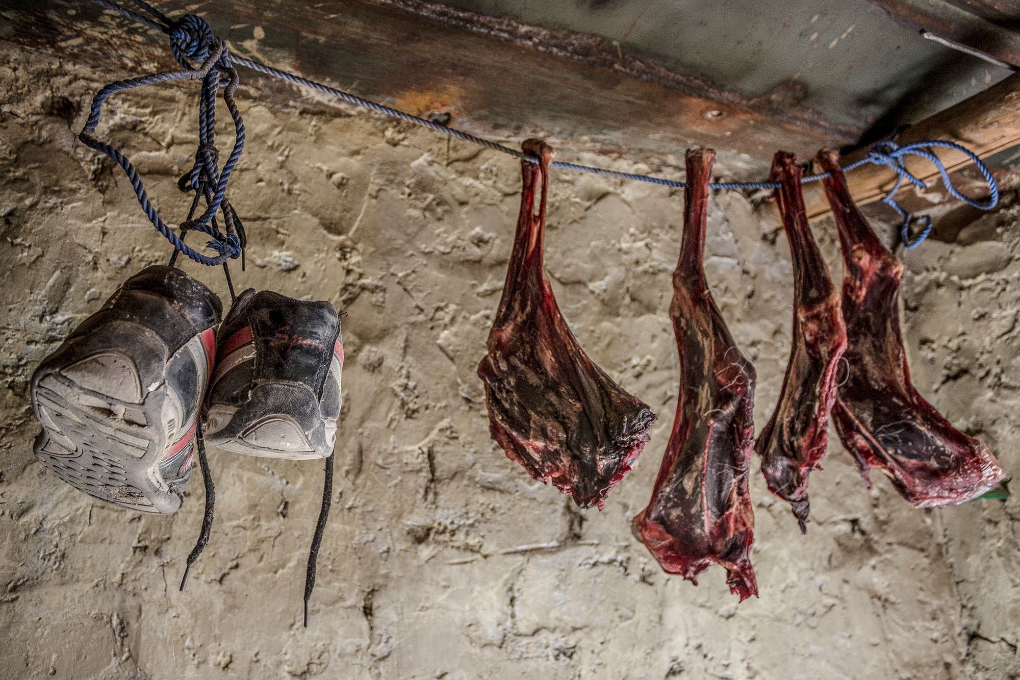 Meat hanging beside a pair of snow boots.jpg